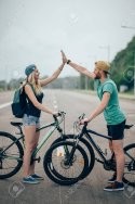 91859399-happy-biker-couple-giving-high-five-while-riding-bicycle-in-countryside.jpg