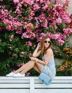 Sydne-Style-wears-Henri-Bendel-denim-bag-in-front-of-bouganveilla-wall-in-Venice.jpg